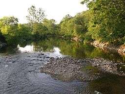 Trees line a meandering river through a rocky area