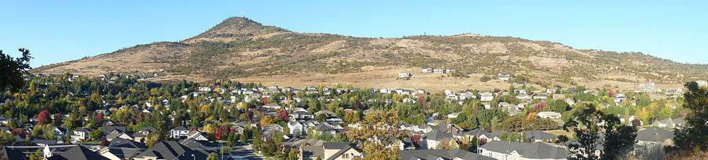 Round-topped mountain rising above hundreds of single-family residences