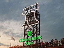 The outline of the Liberty Bell and the logo of Citizens Bank Park against a sunset