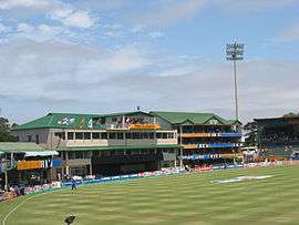 A view of a cricket field focusing towards the pavilion