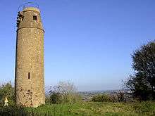 Circular brick tower. Steps and a metal railing are visible at the top.