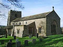 A plain stone church with a clerestory and a battlemented west tower