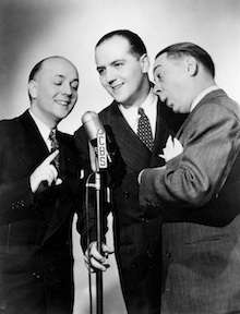 Landt Trio standing around a CBS microphone