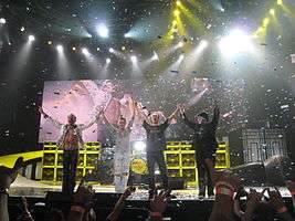 Van Halen standing onstage and waving to the audience