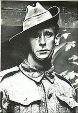 A slightly grainy head and shoulders portrait of a man in military uniform. He is wearing a slouch hat, with the strap coming down under his chin.