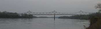 A graceful truss bridge over a broad river.