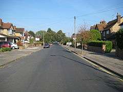 Wide, leafy suburban road with 1930s detached houses