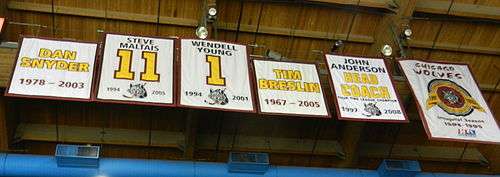 six banners hanging from the ceiling. They vary in size and shape each has yellow lettering with maroon trim describing what they represent.